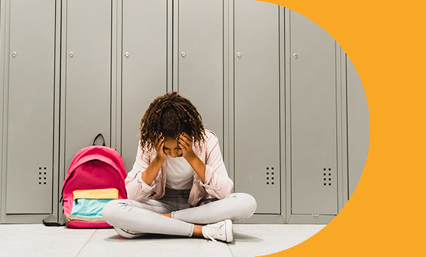 Young girl having a bad day sitting by lockers